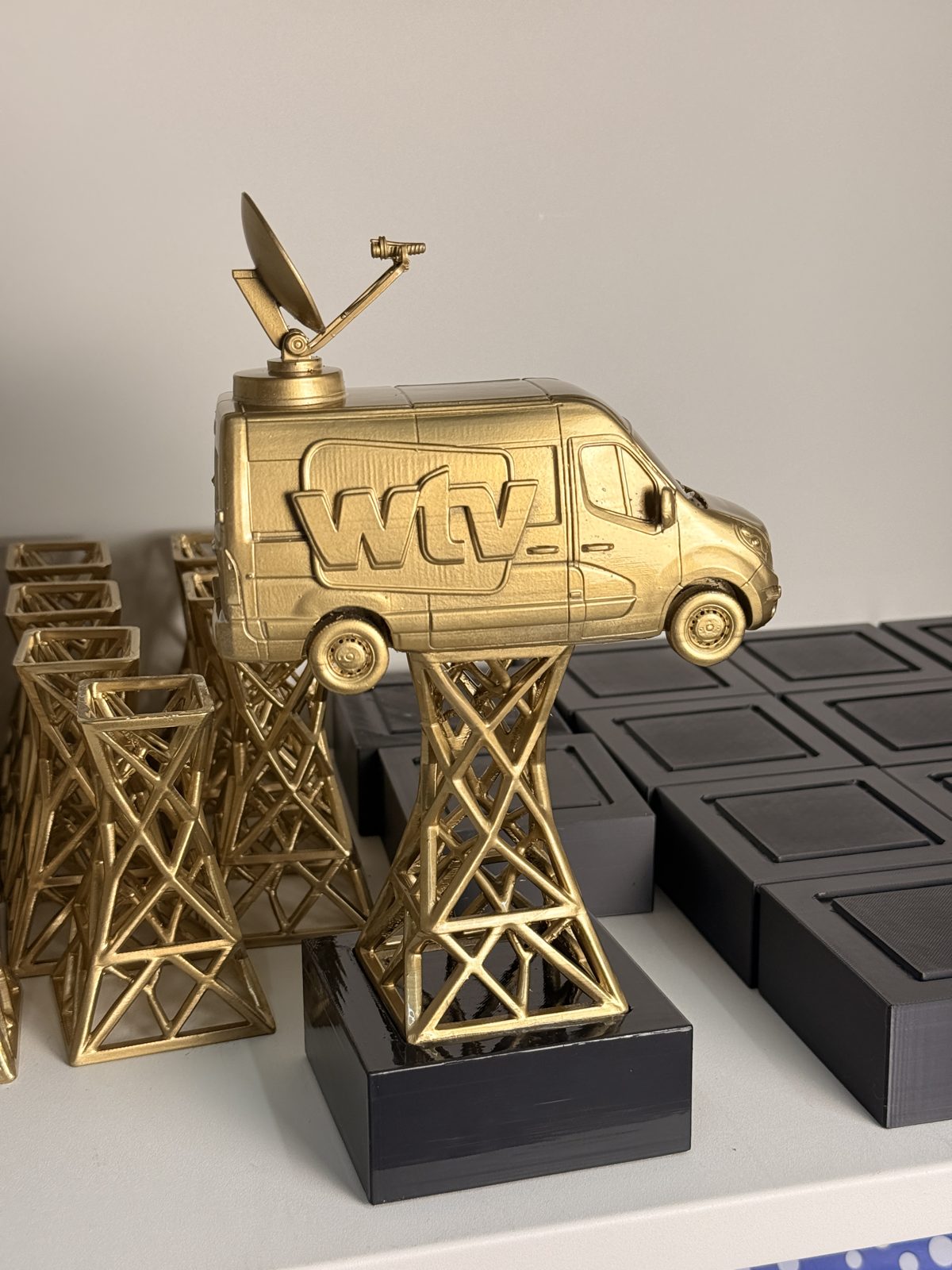 Troféu personalizado impresso em 3D com carrinha dourada sobre torre metálica